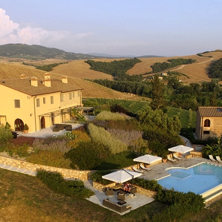 A beautiful ivory swimming pool among the olive trees of Tuscany